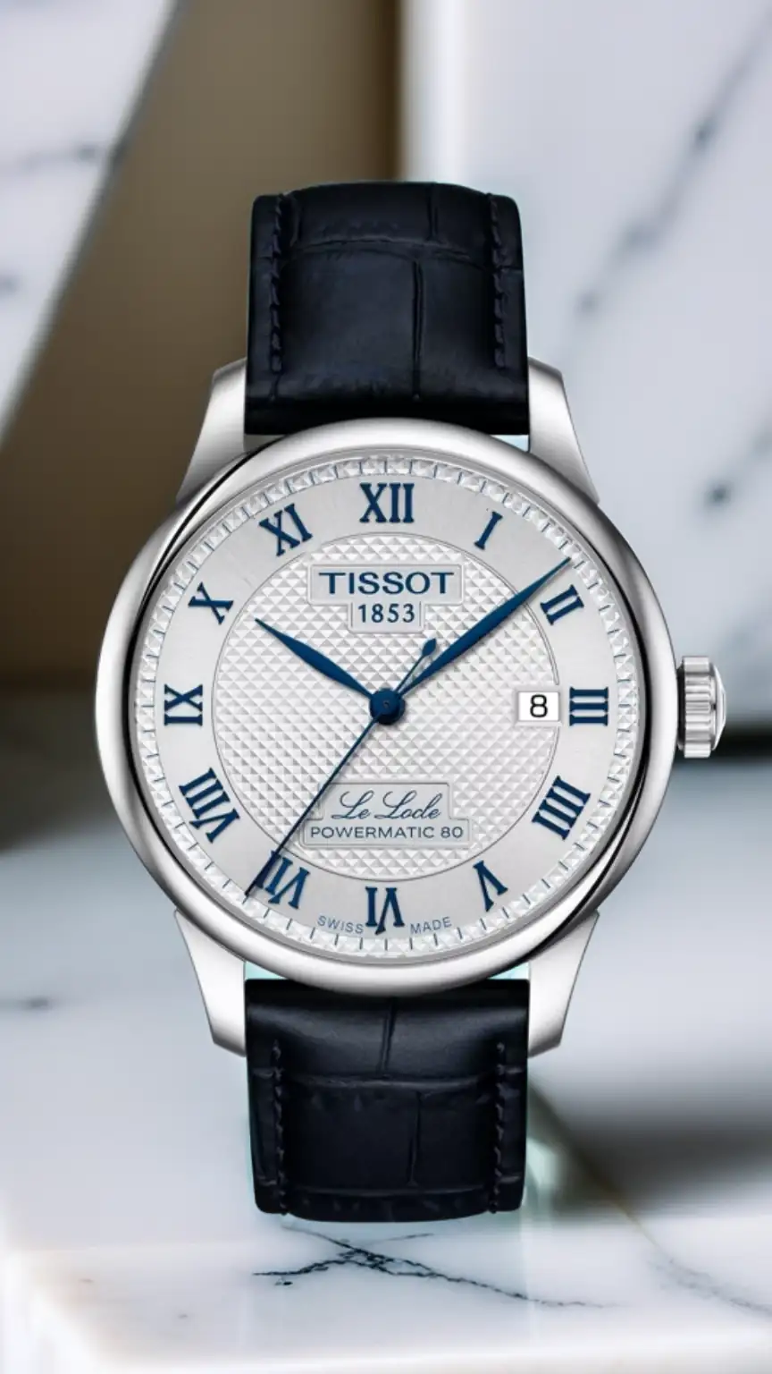 Man in a suit wearing a Tissot Le Locle watch, representing mid-range stylish men's watches. Best Swiss watches, Tissot for business, elegant timepieces.